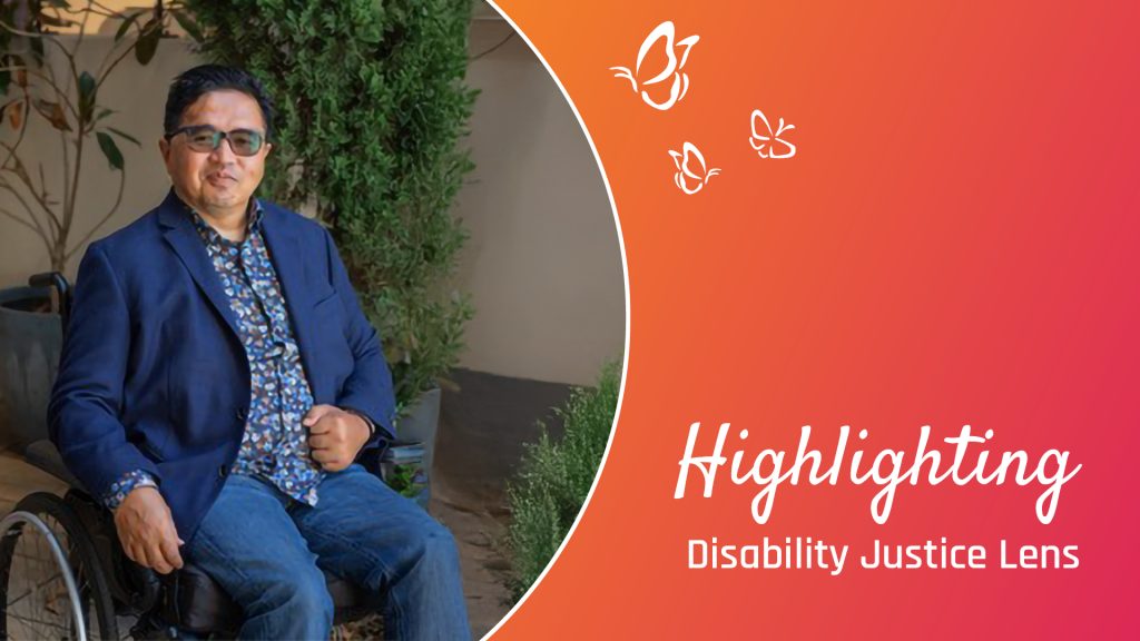 A person seated in a wheelchair wears a blue blazer and a patterned shirt, positioned in front of a backdrop featuring lush greenery and a potted plant. An orange gradient overlays the right side of the image, adorned with white butterfly illustrations. The text "Highlighting Disability Justice Lens" appears prominently, reinforcing the theme of advocacy and inclusion.