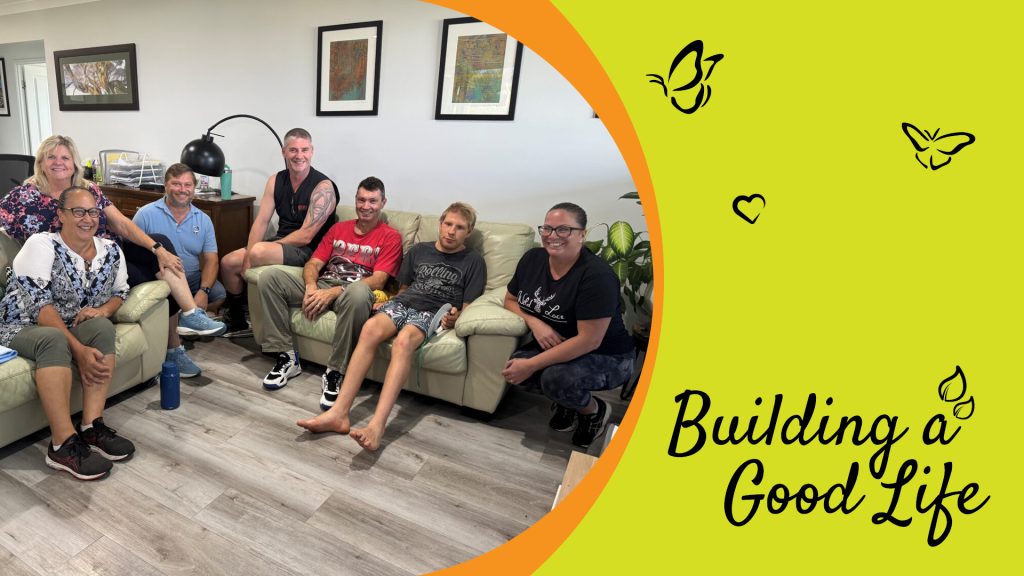 A picture of group of people sitting in a living room on lounge chairs smiling at the camera. the image is on the left side of the banner, with the right side curving into a half circle. the image has a border of orange, which separates the image from the background of the right side of the banner. Which is yellow-green with black icons of butterflies, a heart and leaves spread around the background. Their is also black text that reads "Building a Good Life"